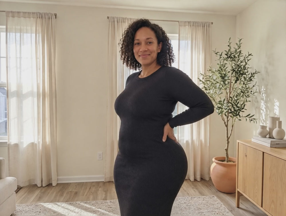 Mom in a fitted black dress turning to show a smooth silhouette
